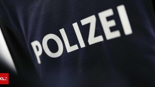 Eine Nahaufnahme eines dunkelblauen Uniforms mit dem Wort 'POLIZEI' in weißer Schrift.
