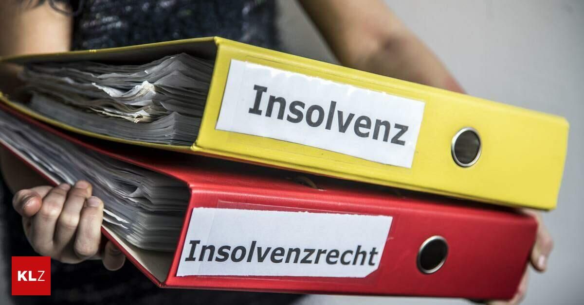 Zwei Ordner gestapelt, einer mit der Aufschrift 'Insolvenz' und der andere mit 'Insolvenzrecht', beide mit vielen Seiten innen, gehalten vom Arm einer Person.