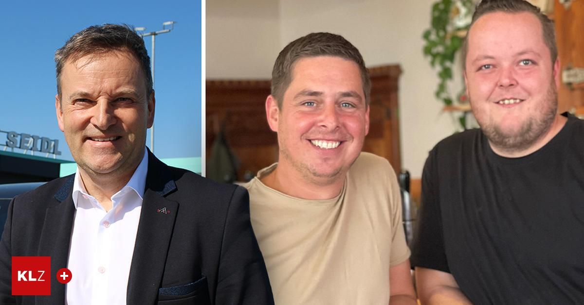 Drei Männer lächeln für ein Foto. Der linke Mann trägt einen schwarzen Anzug. Der mittlere Mann trägt ein beiges T-Shirt. Der rechte Mann trägt ein schwarzes T-Shirt. Der Hintergrund besteht aus einer hölzernen Wand und einer grünen Pflanze.