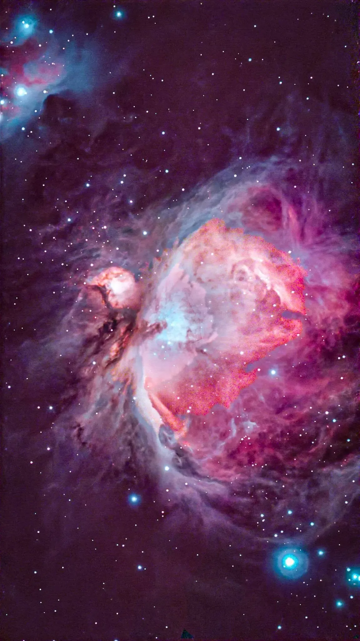 Ein Nebel mit leuchtenden rosa und blauen Farbtönen, zentraler Prominenz und umgebenden Gaswolken. Verstreute Sterne zieren den Hintergrund.