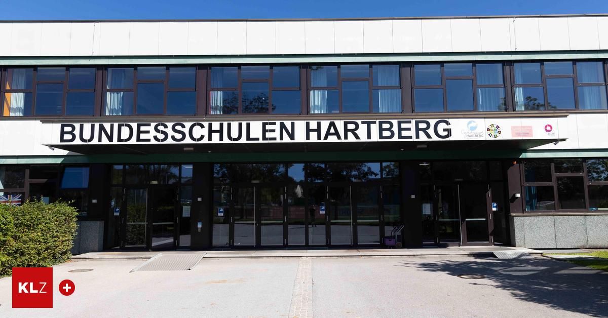 The front entrance of the Hartberg School building with glass windows and doors. A sign above reads 'DESSCHULEN HARTBARG'.