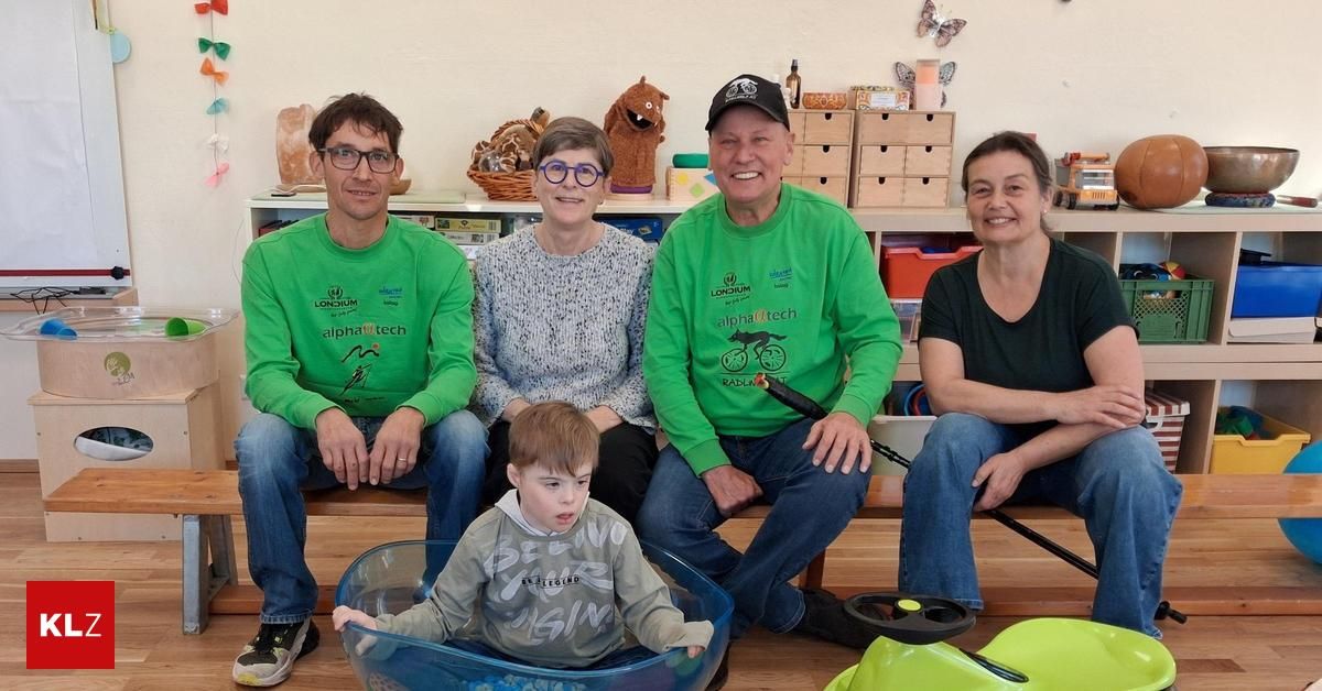 Eine Familie mit fünf Personen posiert für ein Foto mit einem kleinen Jungen in einem Becken, trägt grüne Londonium-T-Shirts, und ein Regal mit verschiedenen Gegenständen dahinter.