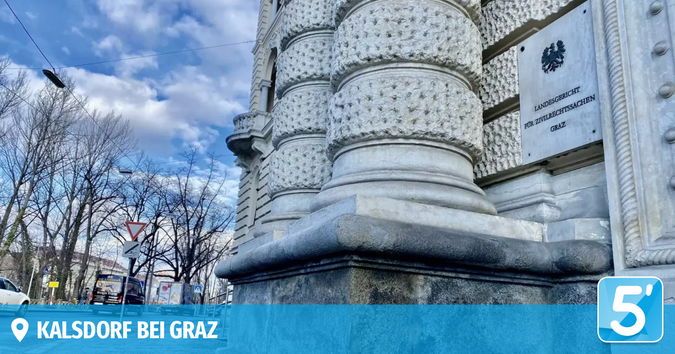 Eine Außenansicht eines historischen Gebäudes mit dekorativen Säulen und einem Schild, das 'Landesgericht für Zivilrechtssachen Graz' besagt. Der Himmel ist blau mit Wolken, und es gibt Bäume und geparkte Autos im Hintergrund.