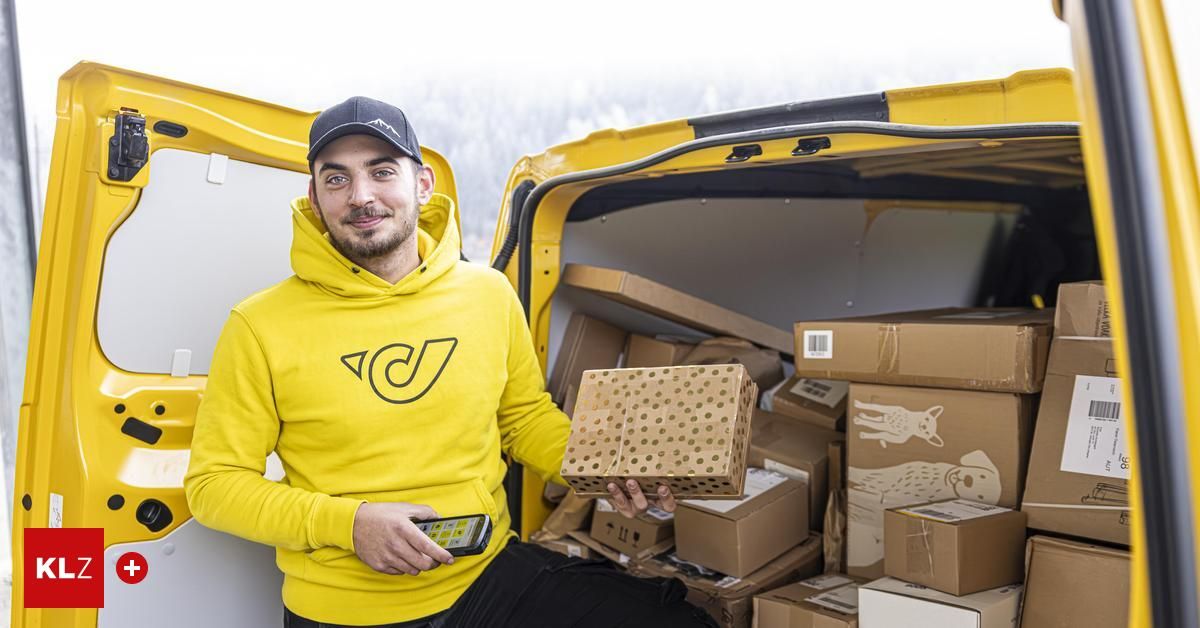 Ein Mann in einer gelben Kapuzenjacke steht neben einem gelben Van, hält eine Box mit Punkten und lächelt in die Kamera, umgeben von vielen Kisten im Van.