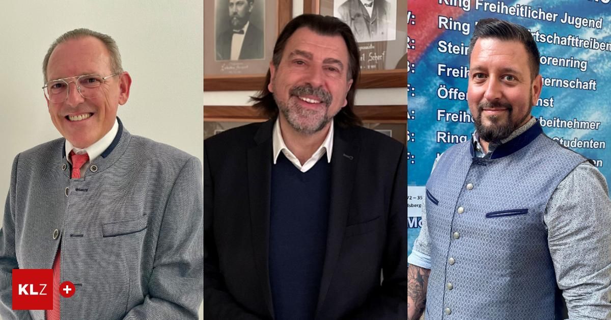 Drei Männer stehen vor einem Banner. Der Mann in der Mitte hat lange Haare und trägt einen dunklen Anzug. Der Mann auf der linken Seite trägt einen hellgrauen Blazer. Der Mann auf der rechten Seite trägt ein blaues Hemd.