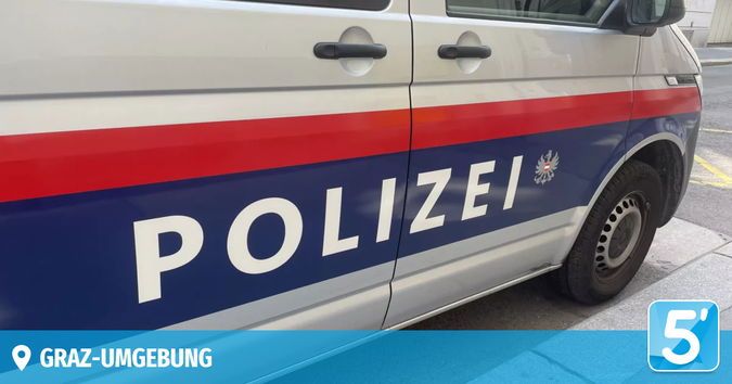 Ein Polizeiwagen mit roten und weißen Streifen ist am Straßenrand geparkt. Das Wort 'POLIZEI' ist in Weiß auf der blauen Seite des Vans geschrieben.