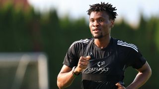 Ein Mann in einem schwarzen Trikot mit der Nummer 27 läuft auf einem Feld. Er schaut zur Seite.