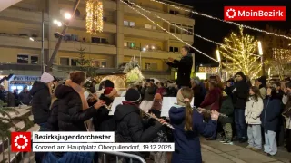 Ein Orchester spielt auf dem Hauptplatz von Oberpullendorf, beleuchtet von festlichen Lichtern, am 19.12.2025.