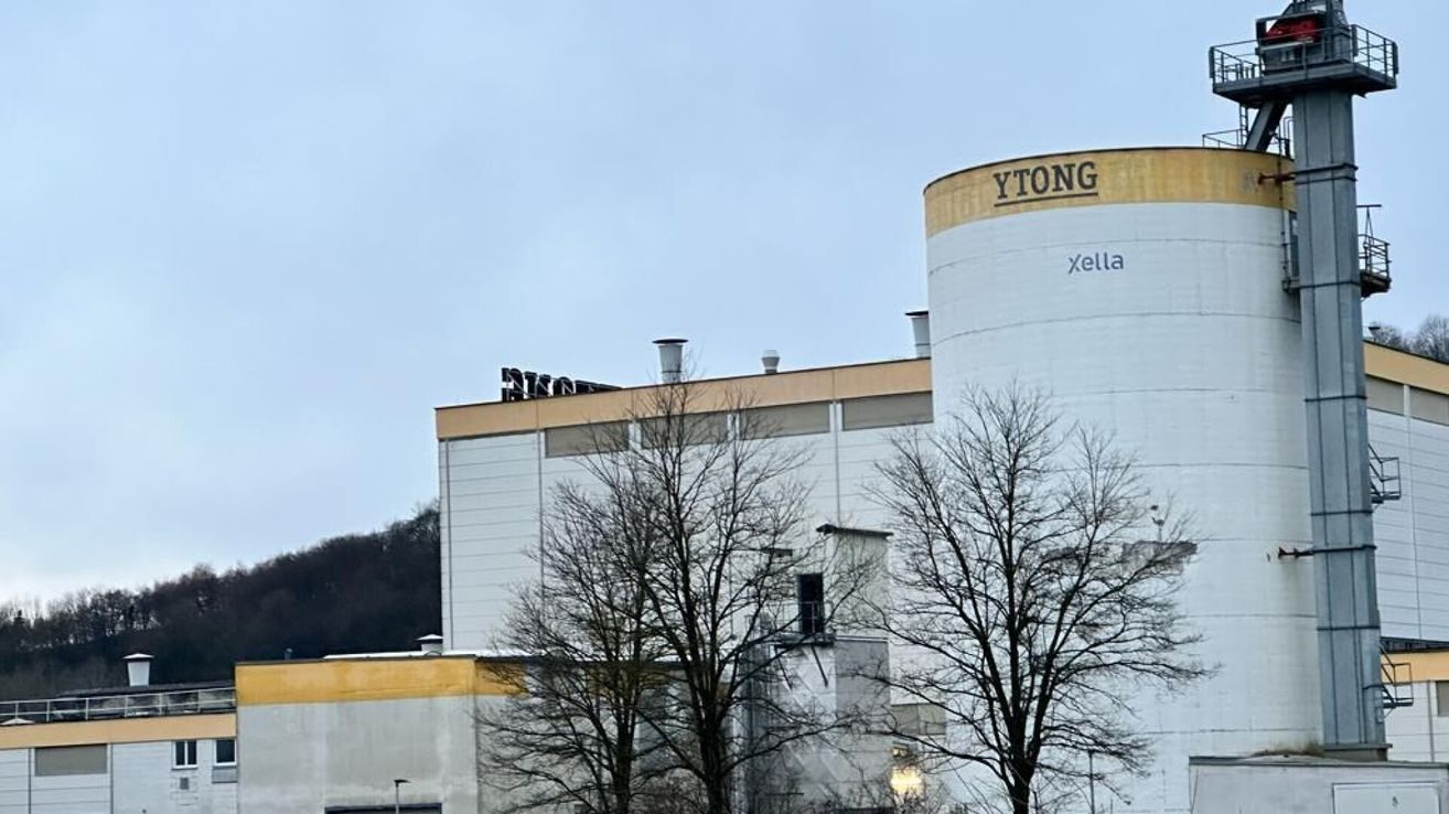 Ein großes Gebäude mit dem Namen Ytong auf der Spitze, es ist eine Produktionsanlage mit laublosen Bäumen davor.