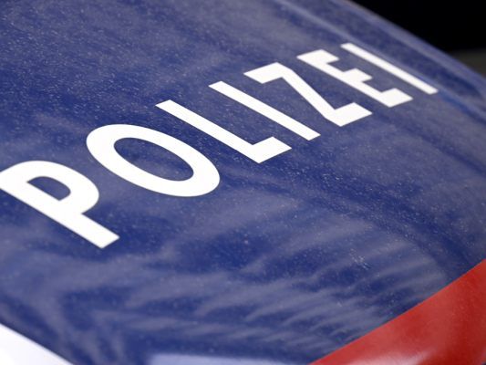 Nahaufnahme eines Polizeiwagens mit dem Wort 'POLIZEI' in weiß auf blauem Hintergrund geschrieben.