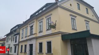 Ein gelbes Gebäude mit mehreren Fenstern und einem Schild, das "Gastwirtschaft Zum Winzerhof" besagt, an der Wand angebracht.