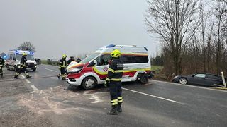 Ein Krankenwagen steht am Straßenrand, mehrere Feuerwehrleute kümmern sich um den Unfallort, einer von ihnen trägt einen gelben Helm.