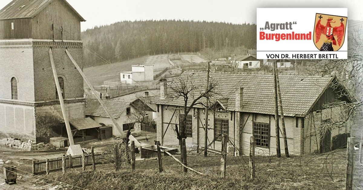 Ein Schwarz-Weiß-Bild eines Dorfes mit Häusern, einem Turm und einem Wald im Hintergrund. Rechts ist ein Schild mit dem Text 'Aggratt Burgenland' zu sehen.