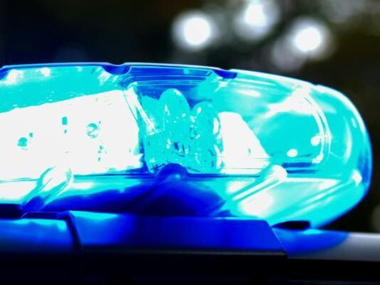 Nahaufnahme eines blauen Notfallfahrzeuglichts, das hell leuchtet und mit einem hellen Schein leuchtet, auf dem Dach eines Fahrzeugs montiert.