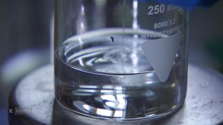 Eine Nahaufnahme eines Bechers, der mit 250 ml, Boro 3.3 und einer kleinen Flüssigkeitsmenge innen gekennzeichnet ist.