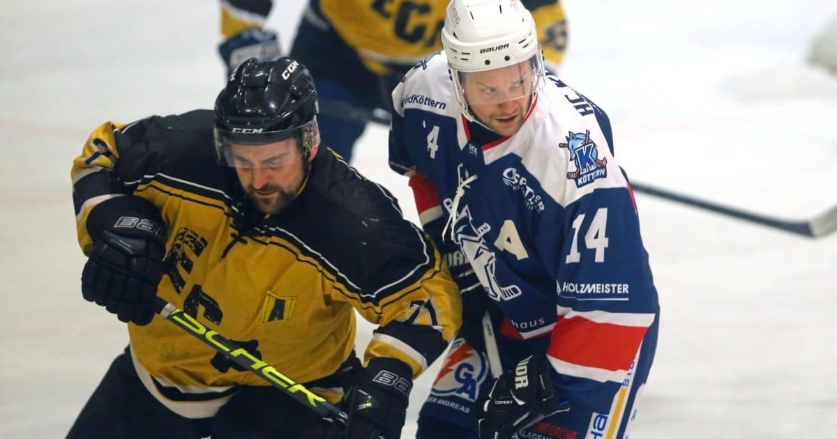 Zwei Eishockeyspieler duellieren sich auf dem Eis. Einer trägt ein gelbes Trikot, der andere ein blaues. Beide sind mit Helmen und Handschuhen ausgestattet. Der Spieler in Gelb hat einen Schläger.