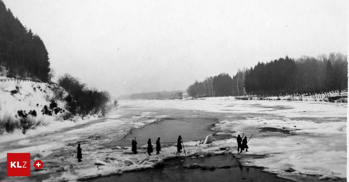 Schwarz-Weiß-Bild von Menschen, die auf schneebedecktem Eis stehen. Mehrere Bäume säumen die Flussufer.