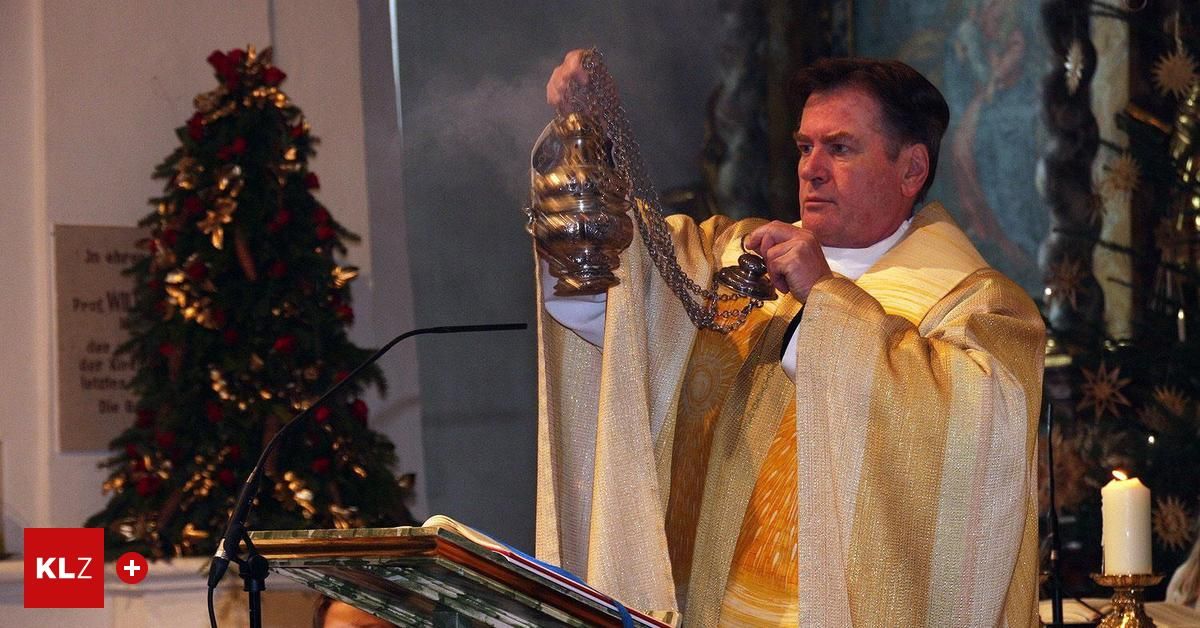 Ein Priester hält eine goldene Lampe und scheint an einem Podium zu sprechen, mit einem Weihnachtsbaum dahinter.