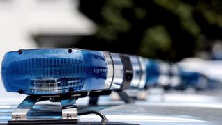 Eine Nahaufnahme von blauen Polizeiautolichtern, die auf einem Fahrzeug blinken.