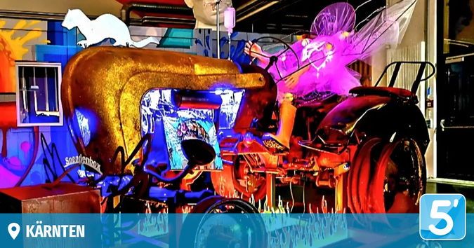 Ein goldener Traktor mit lila Lichtern und einer Feenfigur steht in einem farbenfrohen Raum mit einer Wandmalerei einer Katze und einem Fenster.