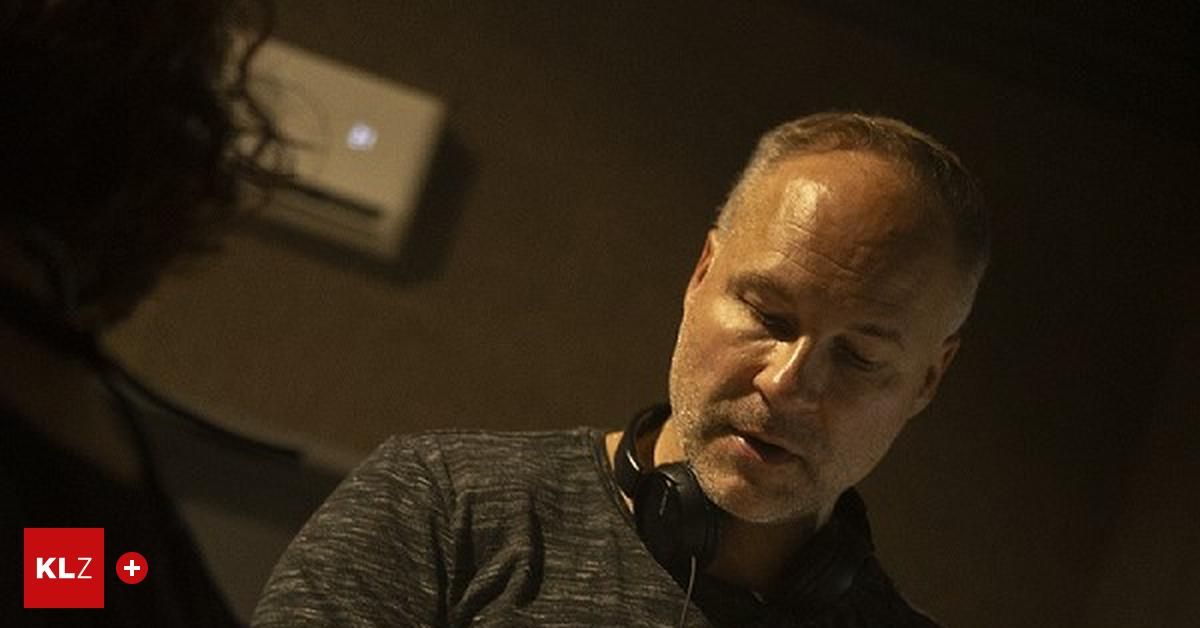 Ein Mann mit Kopfhörern, möglicherweise ein Musiker, befindet sich in einem Aufnahmestudio. Er sieht nachdenklich und konzentriert aus.