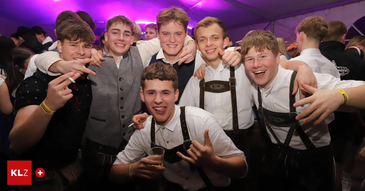 Eine Gruppe junger Männer in traditioneller deutscher Kleidung, lächelnd und für ein Foto bei einer gesellschaftlichen Veranstaltung posierend.