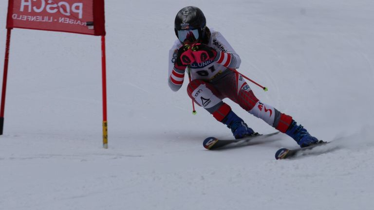 Ein Skifahrer mit der Nummer 81 auf dem Trikot fährt einen verschneiten Hang hinunter, nahe an einem roten Flaggenmarker.