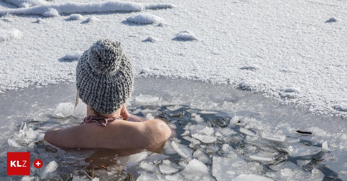 Eine Frau ist in eisige Wasser, trägt eine gestrickte Mütze und scheint die Kälte zu genießen.