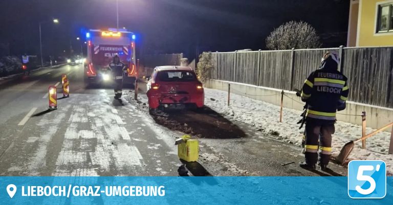 In der Nacht krachte ein rotes Auto in Graz gegen einen Zaun. Feuerwehrleute sichern den Ort.