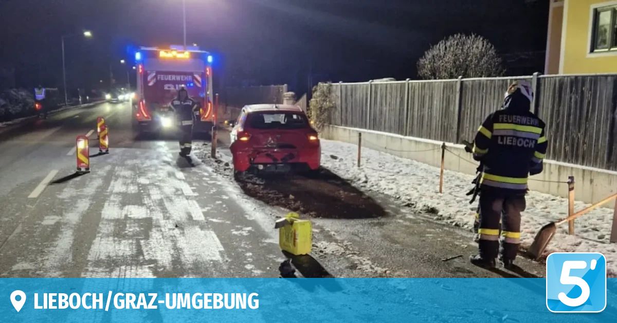 In der Nacht krachte ein rotes Auto in Graz gegen einen Zaun. Feuerwehrleute sichern den Ort.