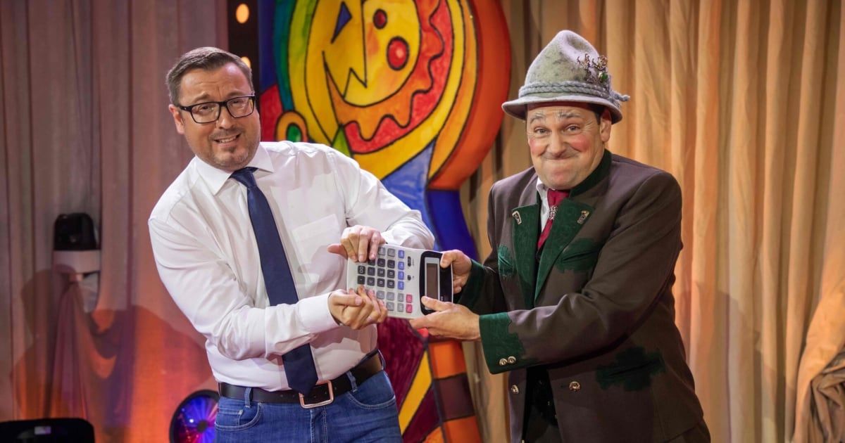 Zwei Männer, einer in Anzug und einer in Hut, halten einen Taschenrechner vor einem bunten Hintergrund.