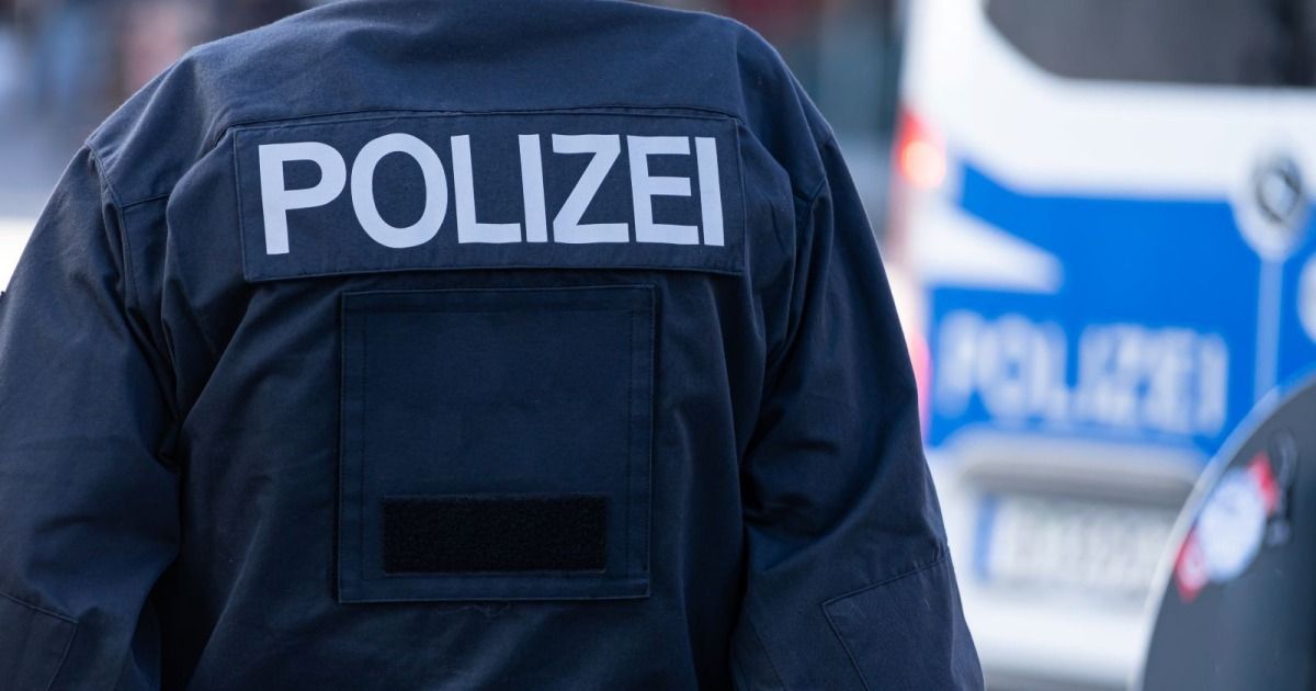 Der Rücken eines dunkelblauen Polizeiuniforms mit dem Wort 'POLIZEI' auf der Schulter aufgedruckt.