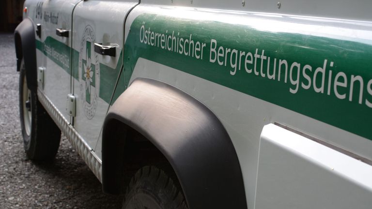 Close-up of a vehicle's side with the text 'Österreichischer Bergrettung' written in white on a green background.