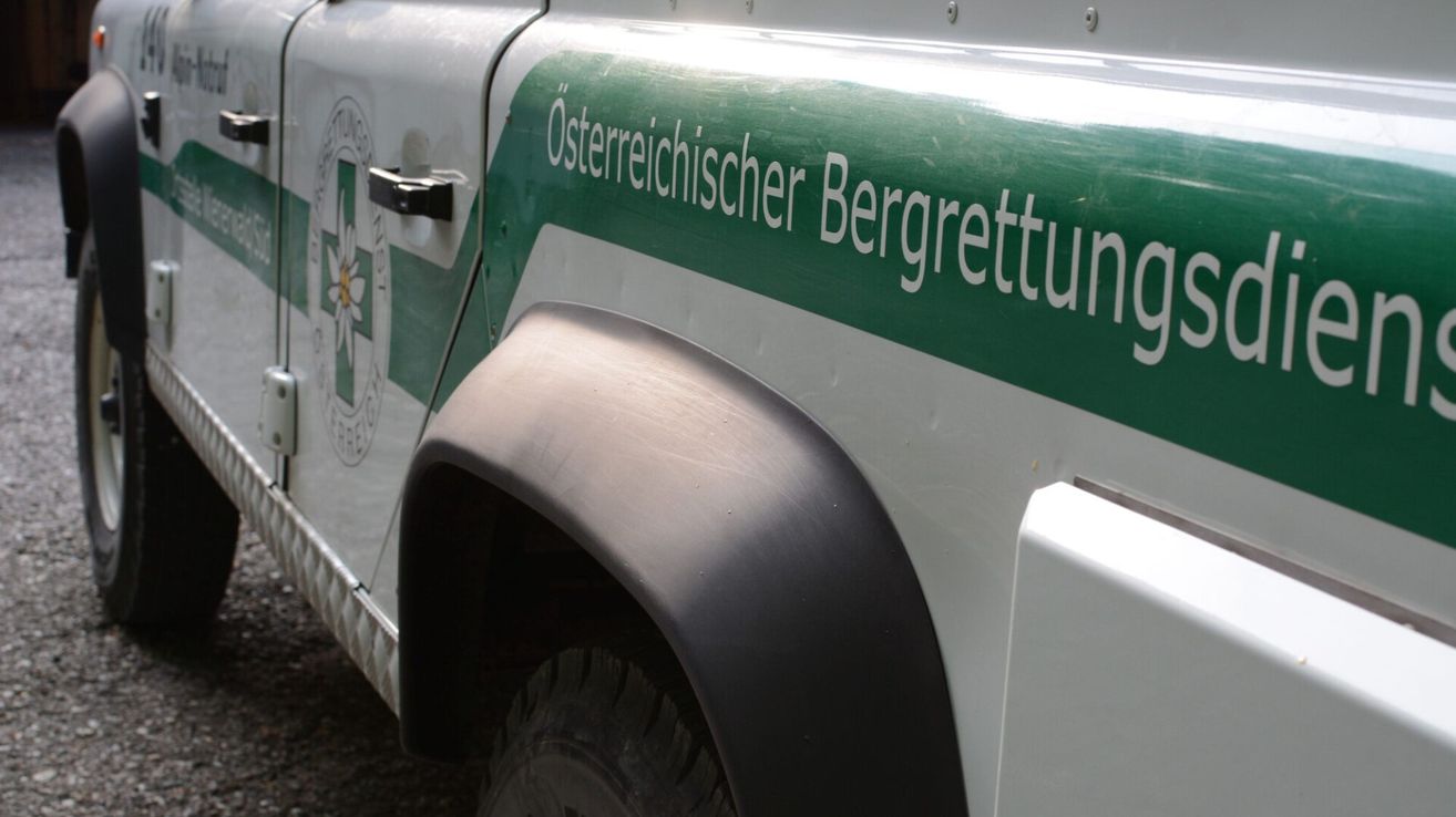 Close-up of a vehicle's side with the text 'Österreichischer Bergrettung' written in white on a green background.