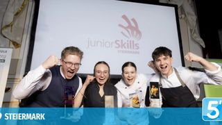 Four young chefs posing with their awards in front of a screen displaying the Junior Skills Steiermark logo.