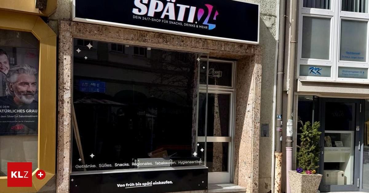 Storefront of Späti 24/7 shop with glass door and window, open signboard, and items listed.