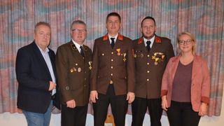 Five men in military uniforms stand next to each other, posing for a photo. They are all wearing medals.