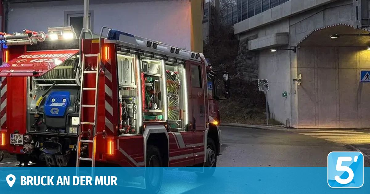 A red fire truck is parked on the side of the road, with its ladder extended and lights on.