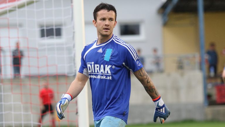 Ein Fußballspieler mit einem blauen Trikot läuft auf dem Feld. Er hat eine Tätowierung am Arm und schaut nach vorne.