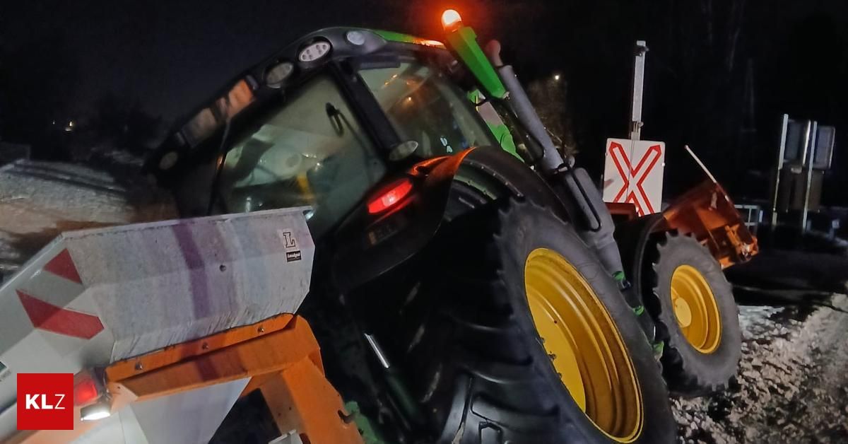 Ein Traktor mit rotem Licht und gelben Felgen steht nachts geparkt.