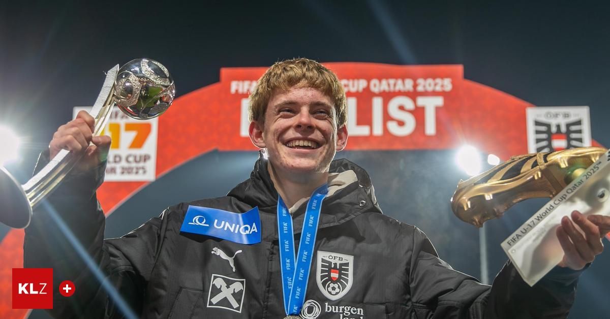 Ein Mann in einer Jacke mit einer blauen Schleife und einer Medaille steht vor einem Schild, das FIFA Cup Katar 2025 Liste besagt.