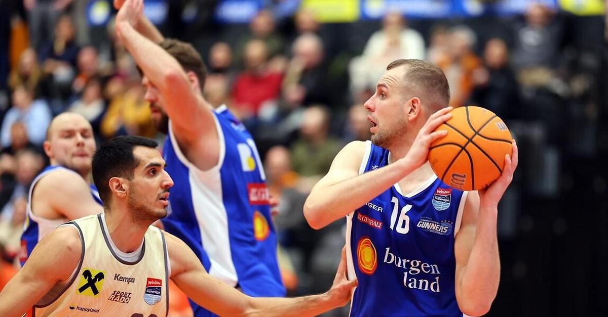 Basketballspieler von zwei Teams spielen ein Spiel. Ein Spieler dribbelt den Ball, während der andere verteidigt. Der Spieler trägt ein Trikot mit der Nummer 16.