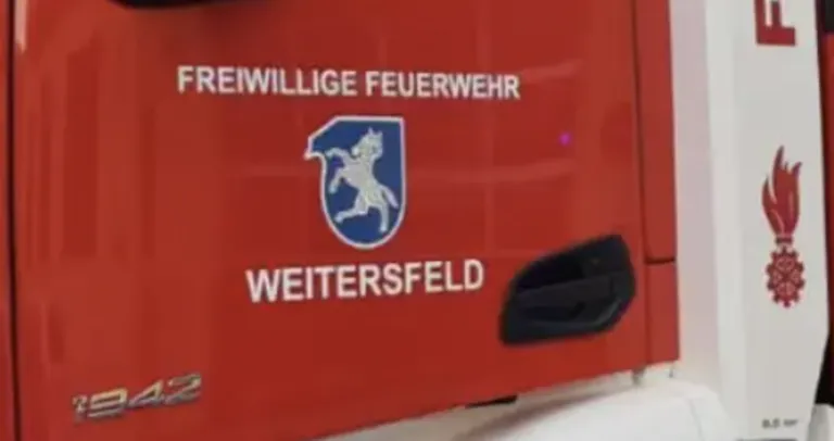 Ein rotes Fahrzeug zeigt das Logo und den Text 'REIWILLIGES FEUERWEHR WEITERSFELD'. Das Logo zeigt ein Pferd und der Text ist in weiß.