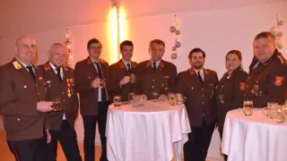 Eine Gruppe von Menschen in Militäruniformen posiert für ein Foto und hält Gläser Bier bei einer Veranstaltung.