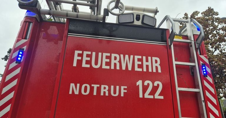 Ein rotes Notfallfahrzeug zeigt 'FEUERWEHR NOTRUF 122'. Es hat ein Lenkrad, Lichter und eine Leiter.