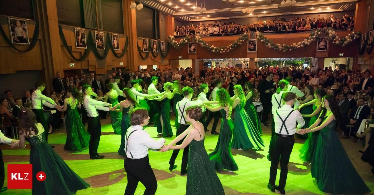 Eine Menschenmenge in formeller Kleidung versammelt sich in einem großen Raum und beobachtet eine Gruppe von Tänzern auf einer grün beleuchteten Tanzfläche.