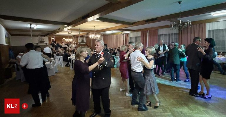 Ein formeller Tanzabend mit älteren Erwachsenen beim Tanzen, einem Mann in Uniform und einer Kronleuchter.