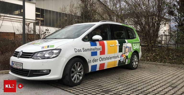 Ein weißer Minivan ist vor einem Gebäude geparkt, mit dem Text 'Das Sammeltaxi in der Oststeiermark' und einer Comicfigur an der Seite.
