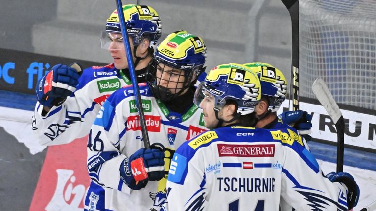 Eine Gruppe von Hockeyspielern mit Helmen und Trikots feiert auf dem Eis. Sie halten Eishockeyschläger in der Hand und schauen sich etwas an. Der Spieler in der Mitte trägt ein Trikot mit dem Wort Generali.