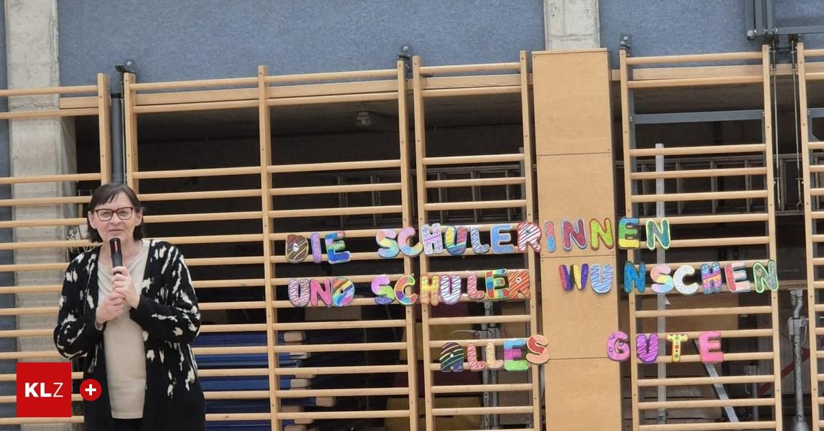 Ein Holzzaun mit bunter Schrift, die 'Die Schulerinnen und Schuler Wuns alles gut' sagt. Eine Person steht links.